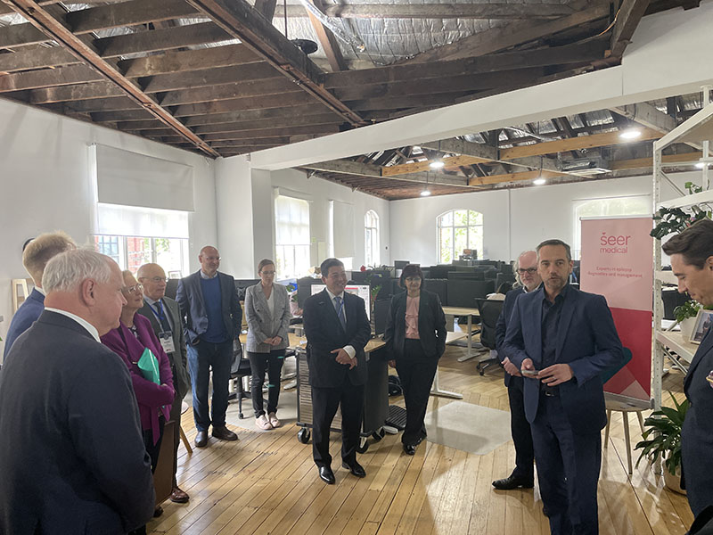 Governor Walz stands speaking with a group of people standing in a circle.