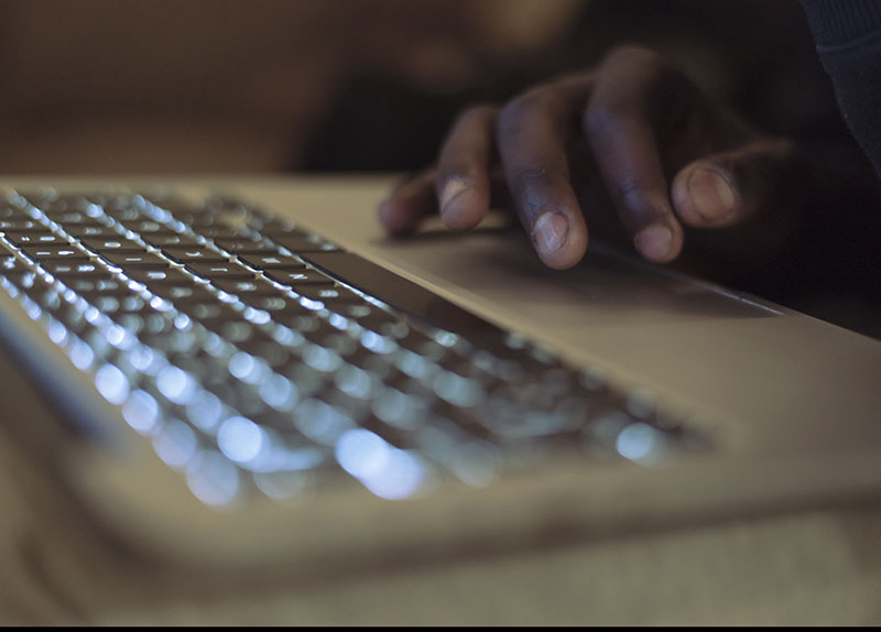 a hand resting on a laptop keyboard