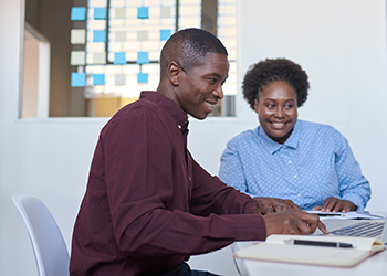 counselor sitting with blind user on adaptive technology