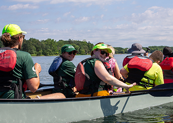 people in a row boat on a river