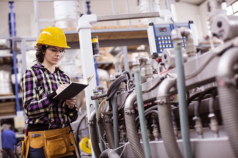 woman-inspecting-machinery-hardhat